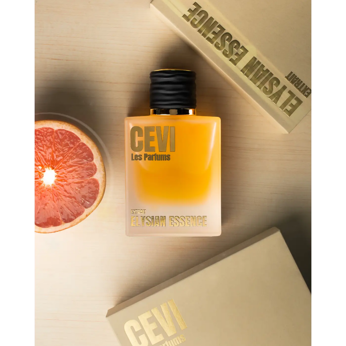 A sleek square bottle of CEVI les parfums elysian essence perfume with gradient amber liquid and gold lettering on frosted glass