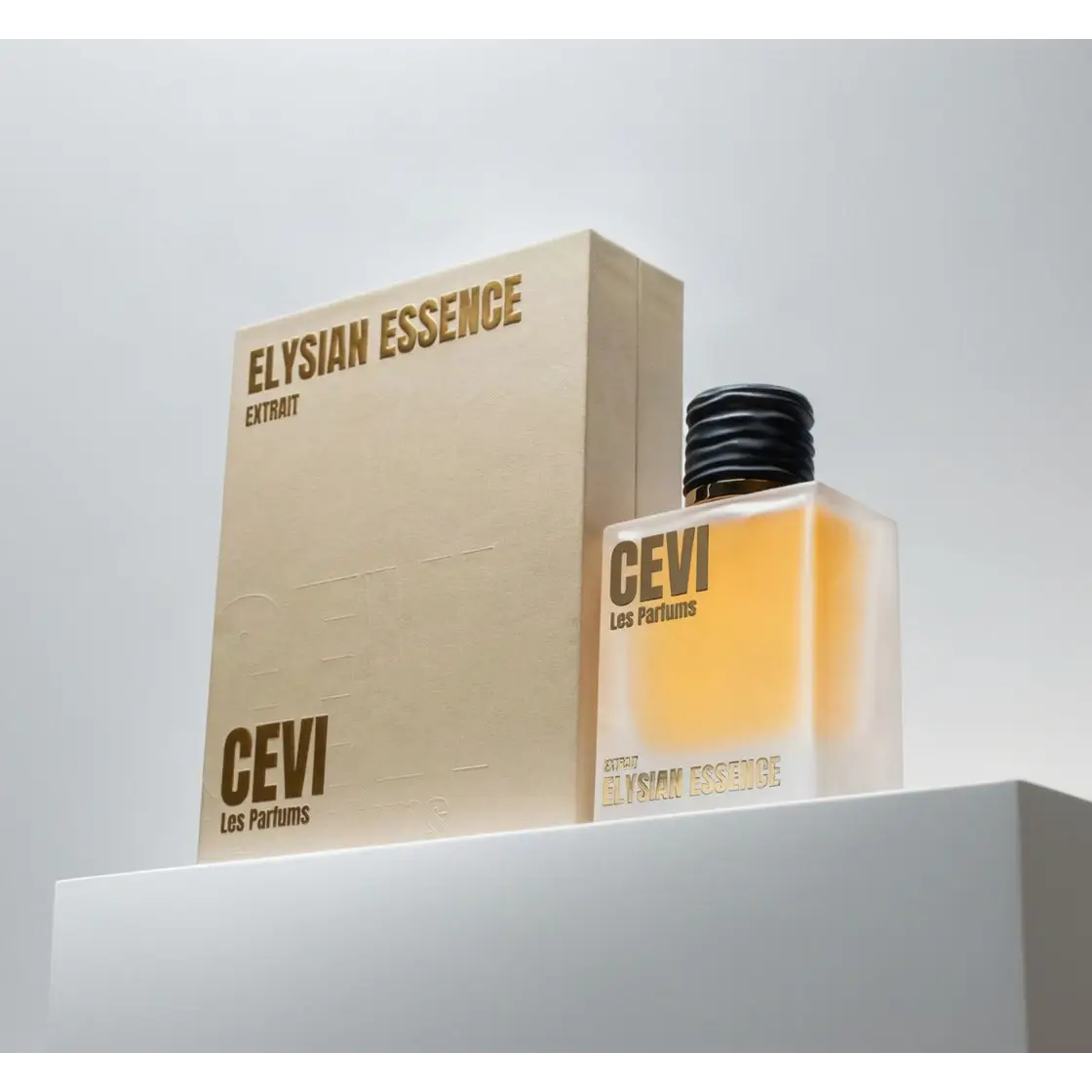 A sleek transparent glass bottle with black ribbed cap and gold lettering containing amber elysian essence perfume