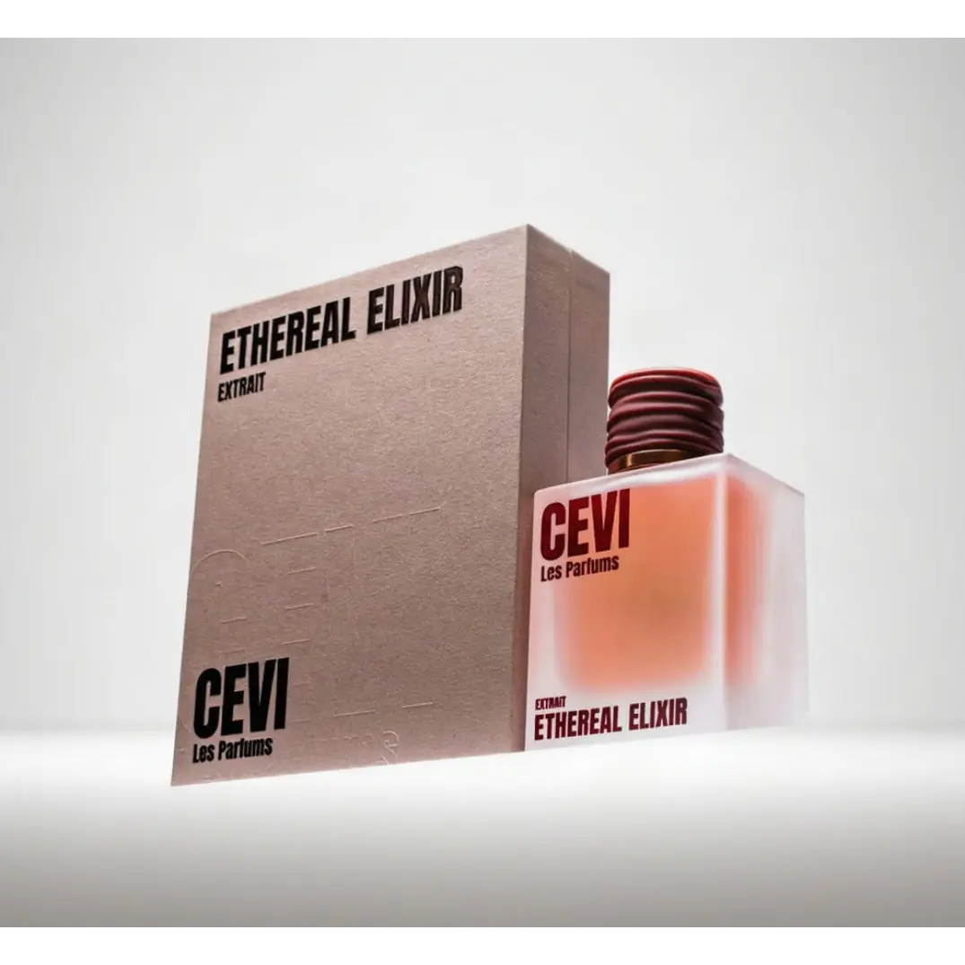 A sleek transparent glass bottle of cevi les parfums ethereal elixir perfume with coral liquid and textured red cap
