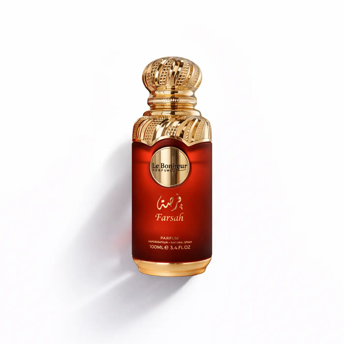 A luxurious red glass perfume bottle with ornate gold cap and base featuring le bonheur farsah fragrance label