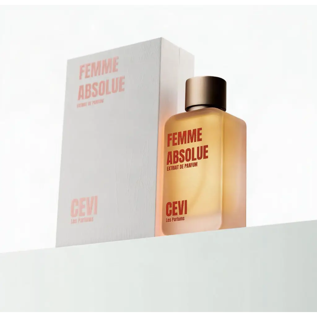 A sleek amber glass bottle of femme absolue cevi extrait de parfum with metallic gold cap and red minimalist typography